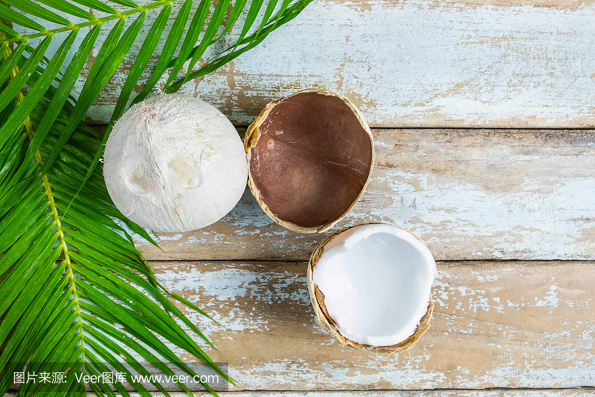 木桌上放兩個(gè)椰子和椰子葉